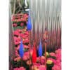 Vivid glass art sculptures among colourful pink flowers at The Kildare Gallery outdoor exhibit.
