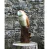Smooth stone owl sculpture on a wooden stand against a textured stone wall at The Kildare Gallery in Ireland.