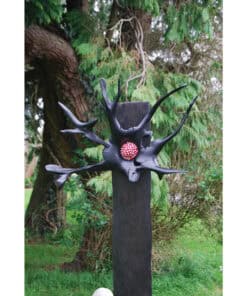 Unique black sculpture with red and white dotted sphere, outdoor garden setting, contemporary art installation, at The Kildare Gallery.
