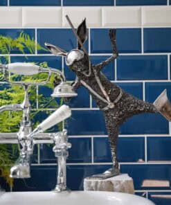 Reflective metal sculpture of a rabbit holding a spoon, part of contemporary art display at The Kildare Gallery.