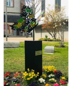 Bright outdoor sculpture garden at The Kildare Gallery, showcasing colourful metal butterfly art and vibrant flower beds.