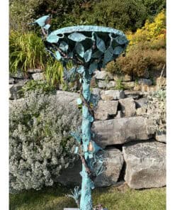 Vivid turquoise metal sculpture of a blooming flower in gardens at The Kildare Gallery, Ireland.