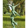 Bronze sculpture of two entwined figures in a lush garden setting.