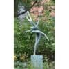 Elegant metal sculpture of a ballet dancer in a garden setting.