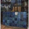 Vibrant abstract oil painting featuring textured blue and green squares, displayed in an artist's studio.