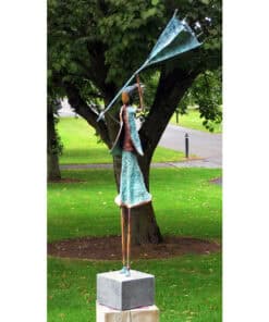 Brilliant butterfly sculpture in park with vibrant green background and mature trees.