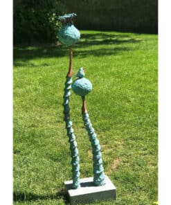Colourful abstract sculpture with textured blue and bronze accents on lush Green grass.
