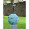 Vibrant outdoor sculpture featuring a abstract human figure on a textured blue spherical base at The Kildare Gallery.