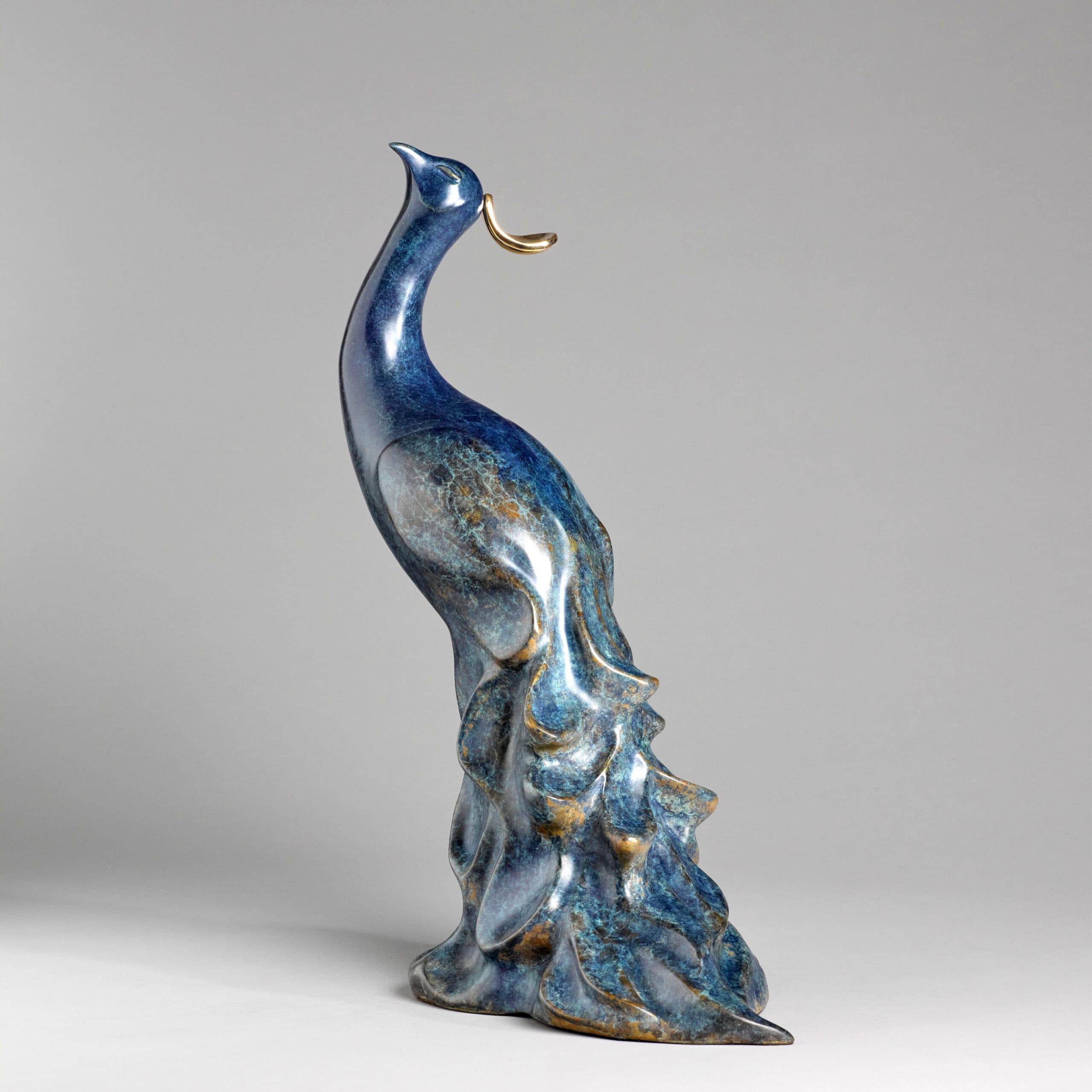 Elegant ceramic sculpture of a stylised bird with blue and gold accents at The Kildare Gallery.
