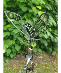 Intricate metal butterfly sculpture with detailed wing patterns, displayed outdoors amidst greenery.