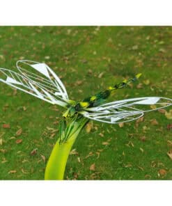 Futuristic dragonfly sculpture in Kildare Gallery garden with green grass background.