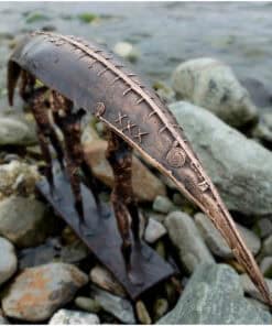 Intricate metal sculpture on rocky shoreline, inspired by natural elements, at The Kildare Gallery.