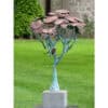 Vivid metal sculpture of a tree with rust-coloured leaves and a small bird, outdoor art installation at The Kildare Gallery.