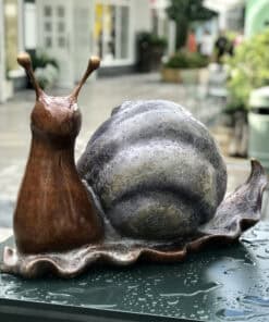 Snail sculpture by The Kildare Gallery, featuring intricate ceramic art of a snail with a metallic shell.