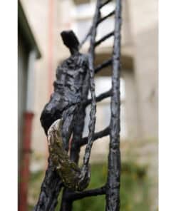 Intricate bronze sculpture of a person climbing a ladder, exhibited at The Kildare Gallery.