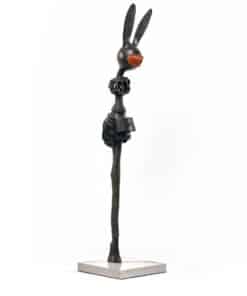 Intricate abstract sculpture of a rabbit in black metal with orange nose, displayed on a white pedestal.