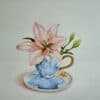 Pink lily flower in a decorative blue and white teacup with matching saucer, studio still life painting, artistic floral art, Kildare Gallery.