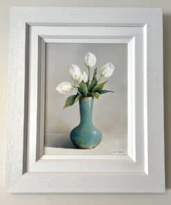 Delicate white tulips in a turquoise vase, displayed in a white wooden frame at The Kildare Gallery.
