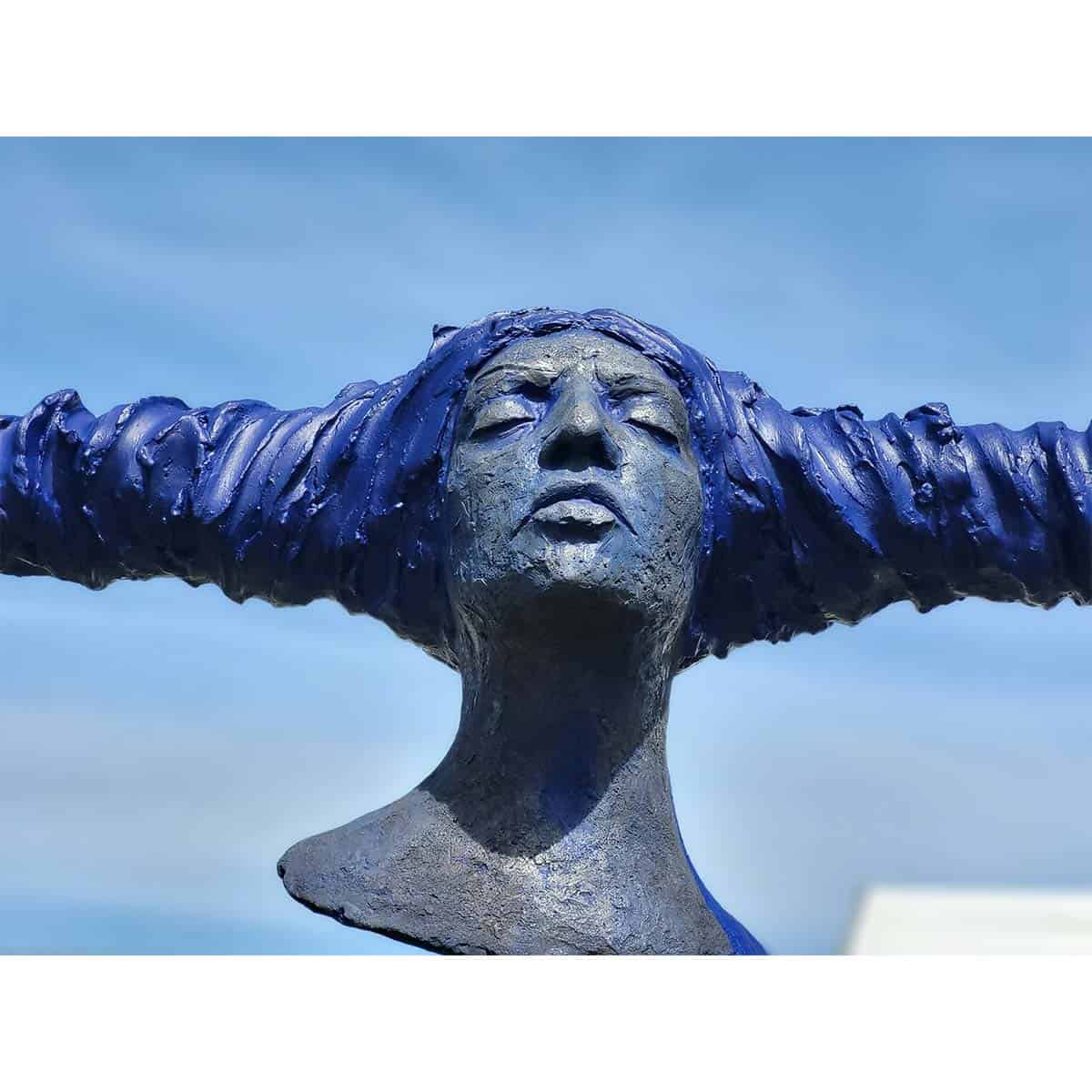 Bronze sculpture of a woman's face with flowing hair, outdoor art piece at The Kildare Gallery.