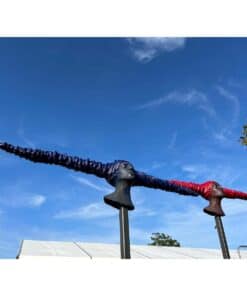 Vibrant outdoor sculpture featuring two female busts with elongated hair, displayed against a blue sky.