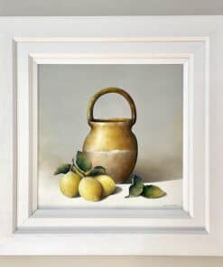 Elegant still life painting of a ceramic jug with lemons and leaves, displayed in a white frame.