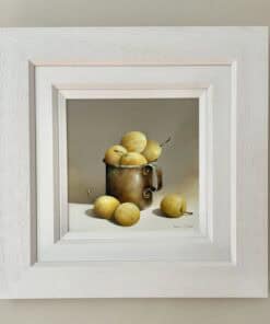 Fresh yellow apples in a metallic mug, framed within a white shadow box, artwork by Sean Curran.