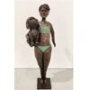A bronze sculpture of a girl in a bikini holding a dog, displayed at The Kildare Gallery in Ireland.