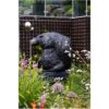 Bronze eagle head sculpture in a lush garden outdoor art piece.
