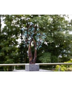 Unique metal sculpture of a tree with blue leaves at The Kildare Gallery gardens, showcasing contemporary artwork in nature.