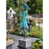 Bright blue metal sculpture of a woman holding an umbrella at The Kildare Gallery outdoor display.