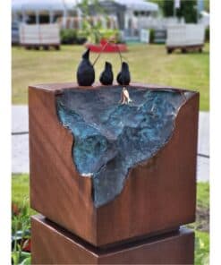 Stone sculpture with three black boats and a fishing net, outdoor art at The Kildare Gallery.
