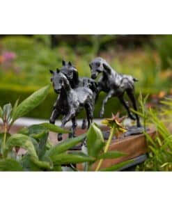 Bronze horse sculptures surrounded by lush green plants at The Kildare Gallery, showcasing expert craftsmanship and artistic elegance.