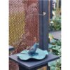 Elegant garden sculpture featuring a blue fox sitting on a leaf-shaped base. Carefully crafted art piece displayed outdoors.