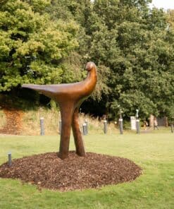 Contemporary bronze bird sculpture at The Kildare Gallery outdoor exhibition in lush green park setting.