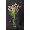 Vibrant mixed flower bouquet in a clear glass vase on a dark background.