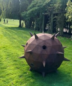 Modern outdoor sculpture by The Kildare Gallery, featuring a spiked spherical design in a lush garden setting.