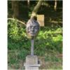 Bronze sculpture of a human head displayed outdoors at The Kildare Gallery with lush greenery background.