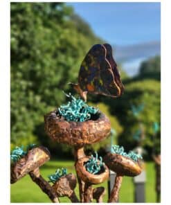 Vibrant outdoor sculpture featuring colorful butterfly and rusted metal floral elements at The Kildare Gallery.