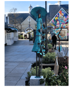 Blue artistic sculpture of a woman with an umbrella, outdoor art display at The Kildare Gallery.