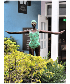 Jewellery sculpture of a woman with arms outstretched in front of The Kildare Gallery, colourful outdoor art display, garden sculpture, Irish art scene.