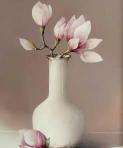 Magnolia flowers in a white ceramic vase on neutral background.