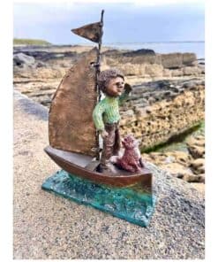 A boy sailing with a dog sculpture on a small boat by the seaside in Kildare.